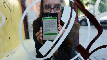 Nina Kov, l'une des développeuses à l'origine de l'application InfoAid, montre l'une de ses pages sur son smartphone, le 14 septembre 2015 à Röszke, en Hongrie [ATTILA KISBENEDEK / AFP]