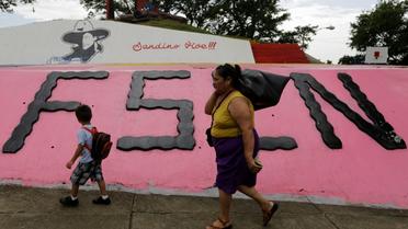 Une femme et un enfant marche devant un monument à la mémoire du révolutionnaire Augusto C. Sandino, à Managua, le 17 juillet 2018 [Inti OCON / AFP/Archives]