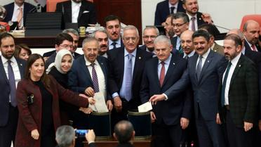 Le Premier ministre turc, Binali Yildirim (3eD) et des parlementaires posent avant de glisser leur bulletin dans l'urne lors du vote prévoyant un changement dans la constitution, au parlement à Ankara, le 14 janvier 2017. [Adem ALTAN / AFP]