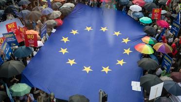 Des manifestants déploient un drapeau européen devant la réprésentation de la Commission européenne, le 26 juin 2018 à Varsovie, pour dénoncer la réforme de la Cour suprême [Wojtek RADWANSKI / AFP/Archives]
