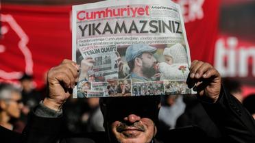 Un manifestant brandit un exemplaire du quotidien d'opposition "Cumhuriyet" devant le siège du journal à Istanbul le 2 novembre 2016 [YASIN AKGUL / AFP/Archives]