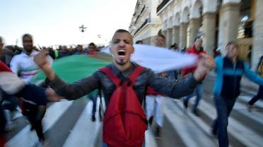 Un manifestant avec un drapeau algérien proteste contre un éventuel 5e mandat du président algérien Abdelaziz Bouteflika, le 22 février 2019 à Alger [RYAD KRAMDI                         / AFP]