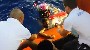 Photo tirée d'une vidéo diffusée le 4 octobre 2013 par les gardes côtes italiens montrant un migrant secouru après le naufrage près de Lampedusa [HO / GUARDIA COSTIERA/AFP/Archives]