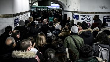 Des personnes font la queue pour accéder au quai de la ligne 1 du métro à Paris, au 8ème de grève dans les transports contre la réforme des retraites, le 12 décembre 2019 [Philippe LOPEZ / AFP]