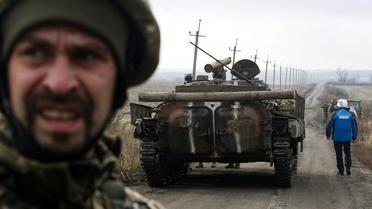 Un observateur de l'OSCE près d'un tank lors d'une mission d'observation du retrait des forces ukrainiennes près du village de Bogdanivka, dans la région de Donetsk en Ukraine, le 9 novembre 2019 [- / AFP]