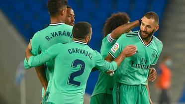 L'attaquant français du Real Madrid, Karim Benzema (d), félicité par ses coéquipiers après son but lors du match de Liga face à la Real Sociedad, à San Sebastian, le 21 juin 2020 [ANDER GILLENEA / AFP]