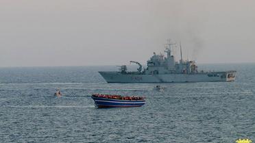 Un bateau de la Marine italienne s'approche d'une embarcation en difficulté remplie de migrants, le 2 avril 2014 en Méditerranée [- / Marine italienne/AFP/Archives]