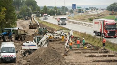 Des ouvriers creusent les fondations d'un mur le long d'une route menant à Calais, le 20 septembre 2016 [PHILIPPE HUGUEN / AFP]