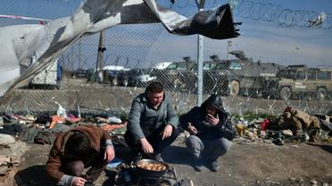 Des migrants font cuire des pommes de terre dans un camp de réfugiés à la frontière entre la Grèce et la Macédoine à Idomeni, le 19 mars 2016 [LOUISA GOULIAMAKI / AFP]