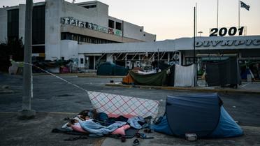 Des migrants dorment près de l'aéroport international d'Athènes le 10 août 2016 [Angelos Tzortzinis / AFP/Archives]