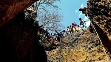 Des mineurs illégaux au bord d'un gouffre où ils espèrent trouver des pierres précieuses, près du village de Nthoro, le 3 août 2018 au Mozambique  [EMIDIO JOSINE / AFP]