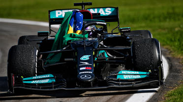 Lewis Hamilton a détaché ses ceintures de sécurité pour s'emparer du drapeau du Brésil.
