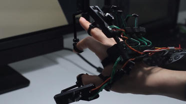 Cette "exomain" permet de toucher et saisir des objets dans un monde virtuel en 3D. 