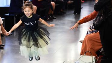Une petite fille s'amuse sur le podium d'un défilé de mode à Milan, le 25 septembre 2016. 