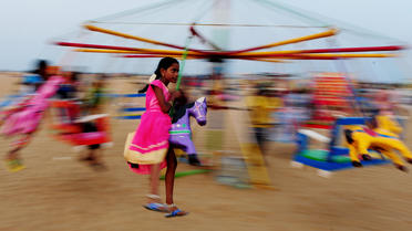 Une petite fille sur un manège à Chennai, dans le sud de l'Inde, en juin 2016.