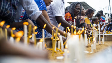 Des fidèles chrétiens sri-lankais allument des bougies alors qu'ils prient devant une barricade près du sanctuaire Saint-Antoine de Colombo, le 28 avril 2019, une semaine après les attentats.