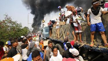 Des Vénézuéliens tentent de sauver les cargaisons d'aide humanitaire entreposées dans un camion en feu, sur un pont à la frontière entre la Colombie et le Venezuela, le 23 février dernier. 