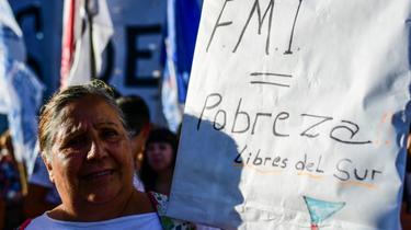 Une manifestante brandit le message "FMI = pauvreté" devant le Parlement argentin à Buenos Aires, le 12 février 2020 [RONALDO SCHEMIDT / AFP]