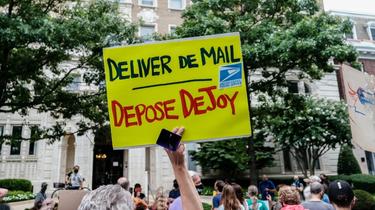 Des manifestants devant le domicile du patron de la poste américaine, Louis DeJoy, le 15 août 2020 à Washington [Michael A. McCoy / GETTY IMAGES NORTH AMERICA/AFP]