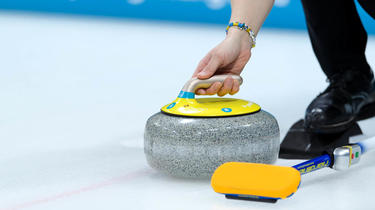 A curling match pits two teams of four players against each other.