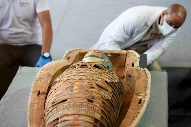 Des archéologues ouvrent un sarcophage découvert à Saqara, lors d'une cérémonie le 14 novembre 2020 [Ahmed HASAN / AFP]