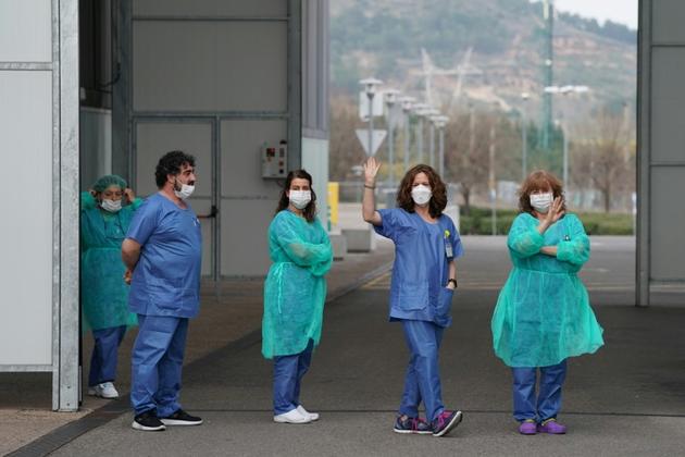 Des membres du personnel soignant prennent quelques minutes de pause devant l'hôpital de Burgos, dans le nord de l'Espagne, le 20 mars 2020 [CESAR MANSO / AFP/Archives]