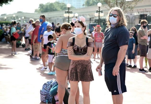 Des visiteurs font la queue à l'entrée de Disney World le jour de sa réouverture à Orlando, en Floride, le 11 juillet 2020 [Gregg Newton / Gregg Newton/AFP]