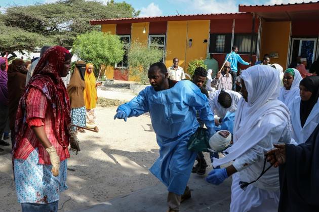 Des secouristes prennent en charge des blessés après l'explosion d'une voiture piégée à Mogadiscio le 28 décembre 2019 [Abdirazak Hussein FARAH / AFP]
