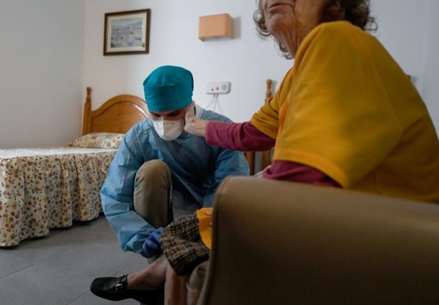Un soignant et la résidente d'une maison de retraite le 24 avril 2020 à Madrid [OSCAR DEL POZO / AFP]