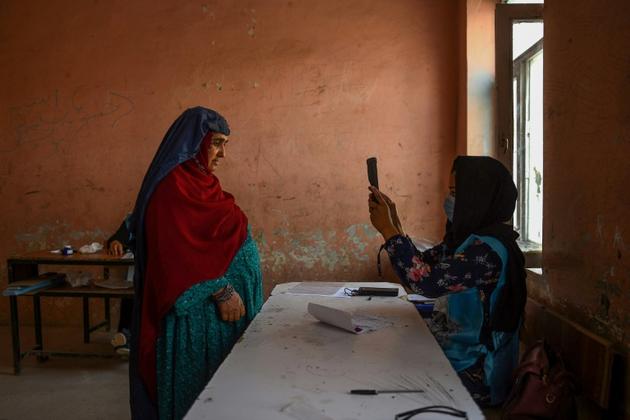 Une responsable de bureau de vote scanne avec un appareil biométrique une électrice, à Mazar-i-Shraif en Afghanistan, le 28 septembre 2019 pour l'élection présidentielle [FARSHAD USYAN / AFP]