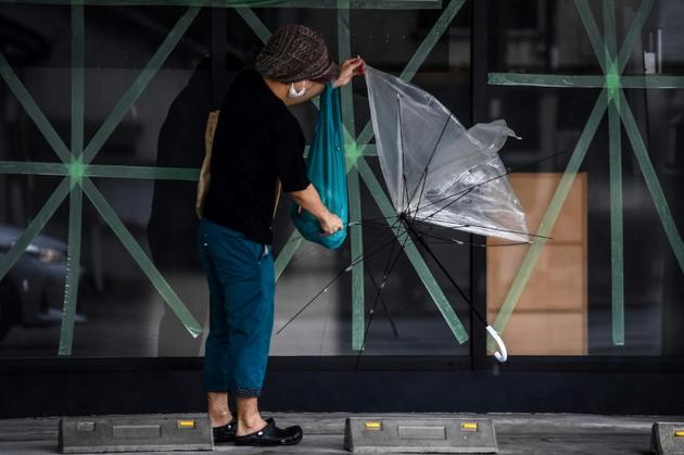 Un homme tient son parapluie brisé alors que le typhon Haishen approche de Kagoshima, au Japon, le 6 septembre 2020<br />
 [CHARLY TRIBALLEAU / AFP]