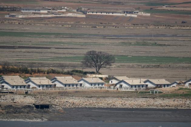 Des champs et des baraquements en Corée du Nord, vus depuis la Zone démilitarisée (DMZ), le 23 avril 2020 à Ganghwa-gun, en Corée du Sud [Ed JONES / AFP/Archives]