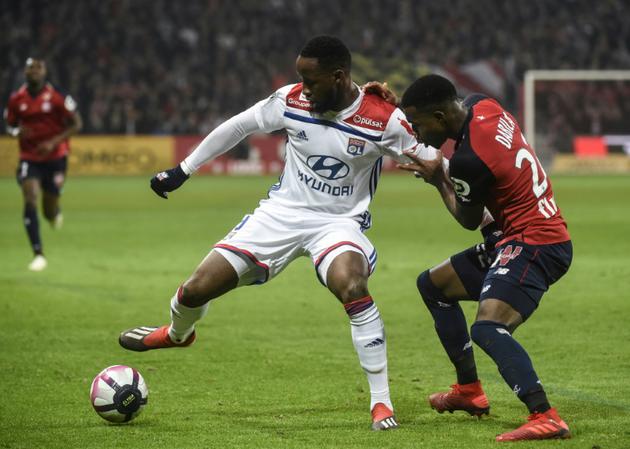 Le Lyonnais Moussa Dembélé (g) face au défenseur lillois Yves Dabila, le 1er décembre 2018 à Villeneuve-d'Ascq [FRANCOIS LO PRESTI / AFP]