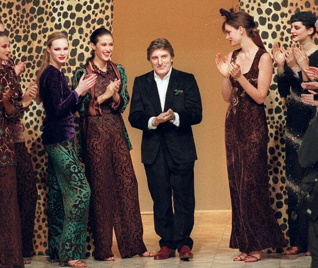 Le couturier français d'origine italienne Emanuel Ungaro au milieu de ses modèles après la présentation de sa collection hiver automne de prêt-à-porter le 16 mars 1997 à Paris [PIERRE VERDY / AFP/Archives]
