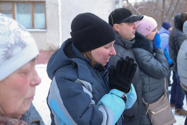 Des passants le 1er janvier 2019 à Magnitogorsk en Russie devant le site d'une explosion au gaz qui a ravagé un immeuble d'habitation [STR / AFP]