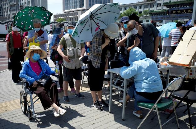 Des Chinois attendent pour se faire tester au coronavirus, le 17 juin 2020 à Pékin, après l'apparition de nouveaux cas [Noel Celis / AFP]