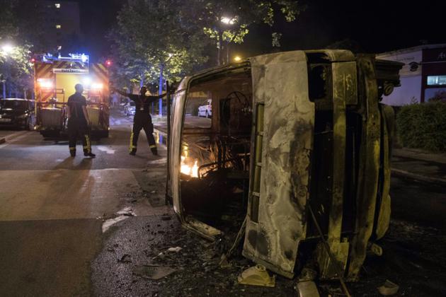 Des policiers près d'une voiture brûlée dans le quartier du Breil à Nantes le 4 juillet 2018 au petit matin [SEBASTIEN SALOM GOMIS / AFP/Archives]