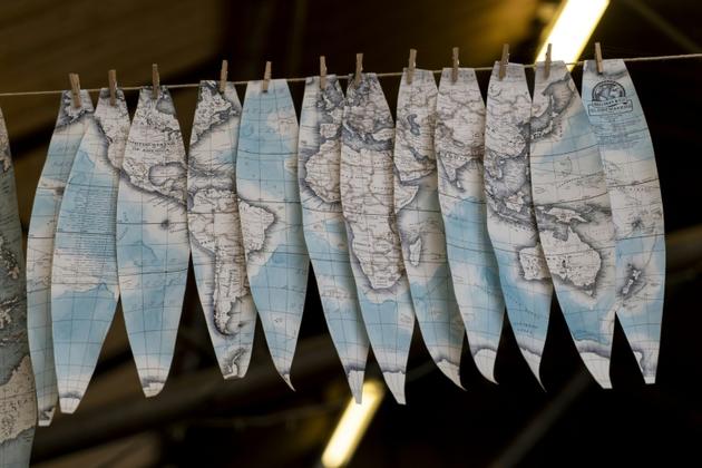 Des cartographies peintes à la main sur des bandes de papier de forme ovale sèchent à l'atelier de Bellerby and Co, le 19 juillet 2019 à Londres [Niklas HALLE'N / AFP]