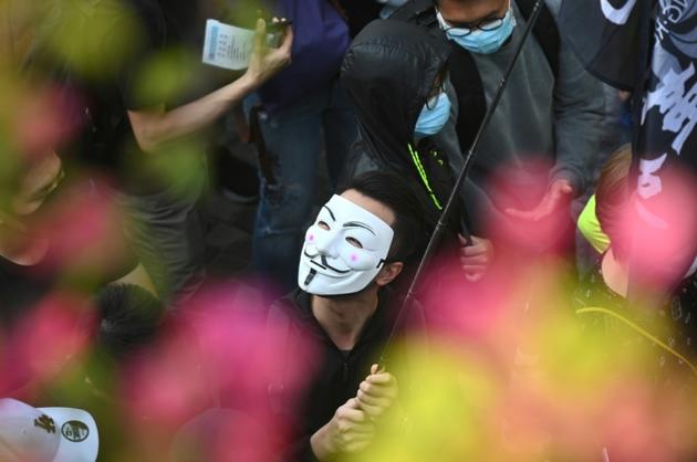 Un manifestant dissimulé derrière un masque de Guy Fawkes, lors d'une marche organisée par le mouvement pro-démocratie à Hong Kong le 1er décembre 2019 [Philip FONG / AFP]