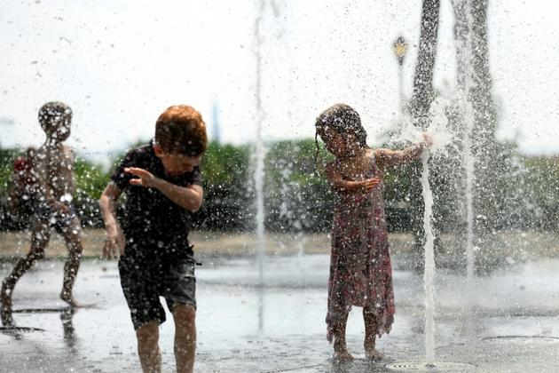 Des enfants jouent dans une fontaine publique à New York, le 19 juillet 2019 [Johannes EISELE / AFP]