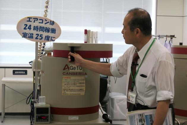 Le directeur du Centre technologique agricole de la préfecture de Fukushima, fait passer des tests de radiation à des échantillons de poisson, à Koriyama, le 1er octobre 2019 au Japon [Karyn NISHIMURA / AFP]