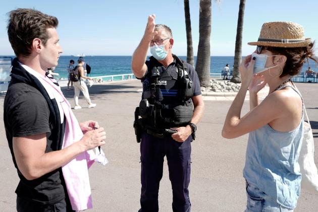 Des policiers informent les passants sur la promenade des Anglais à Nice de l'obligation de porter le masque, le 3 août 2020<br />
 [VALERY HACHE / AFP]