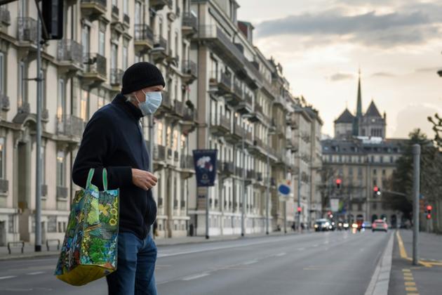 Un passant à Genève (Suisse) le 20 mars 2020 [Fabrice COFFRINI / AFP]