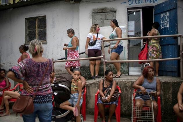 Des femmes font la queue pour une distribution de nourriture dans une favela de Rio de Janeiro, le 7 avril 2020 au Brésil [MAURO PIMENTEL / AFP/Archives]
