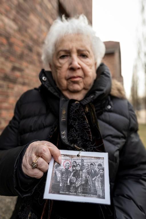 Une survivante de l'Holocauste, Miriam Ziegler, montre une photo d'elle et d'autres prisonniers du camp nazi d'Auschwitz-Birkenau [Wojtek RADWANSKI / AFP]