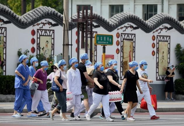 Des membres du personnel médical se préparent à tester les habitants vivant près du marché Xinfadi, nouveau foyer de coronavirus à Pékin, le 16 juin 2020 [Noel Celis / AFP]