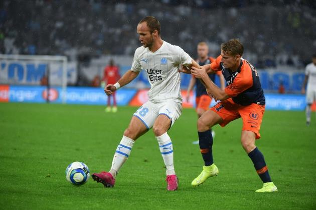 L'attaquant de Marseille Valère Germain (g) à la lutte avec le défenseur de Montpellier Nicolas Cozza, le 21 septembre 2019 à Marseille [SYLVAIN THOMAS / AFP]
