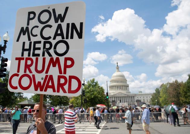 Un militant anti-Trump devant le Capitole, où des centaines de personnes faisaient la queue, le 31 août 2018, à Washington, pour rendre un dernier hommage à John McCain [SAUL LOEB / AFP]