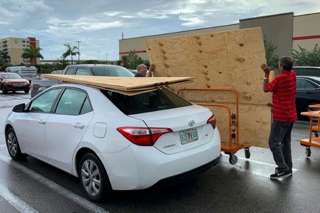 Des habitants de Miami s'équipent de planches en bois pour se protéger de l'ouragan Dorian, le 30 août 2019 [Eva Marie UZCATEGUI / AFP]