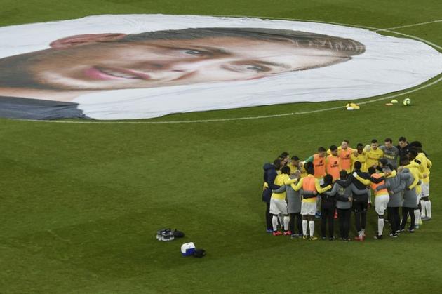 Les joueurs du FC Nantes regroupés près du portrait d'Emiliano Sala,  disparu il y a un an après son transfert à Cardiff, le 26 janvier 2020 avant leur match contre Bordeaux à La Beaujoire [Sebastien SALOM-GOMIS / AFP/Archives]